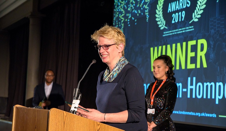 a woman accepts an award at a podium