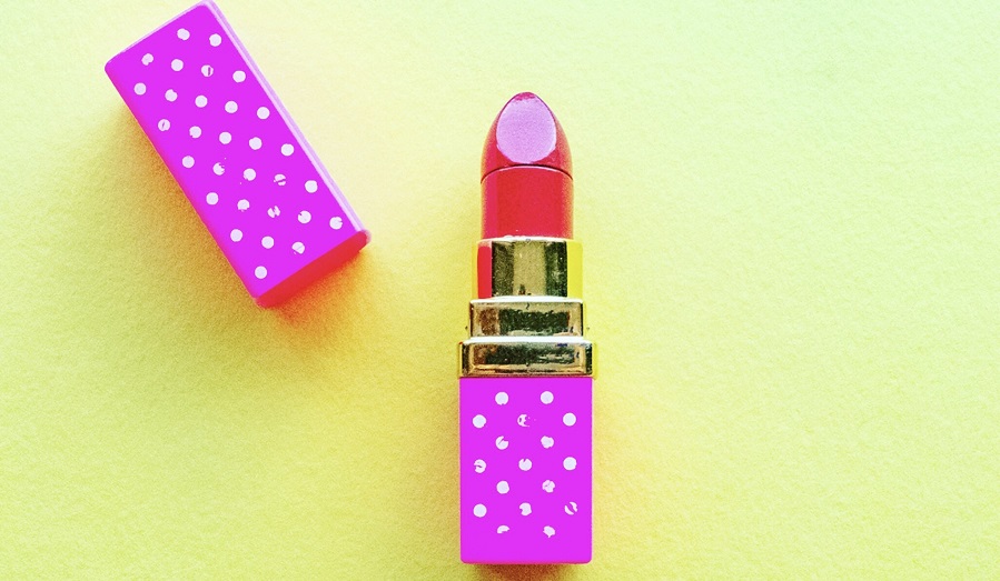 lipstick and lid on green background