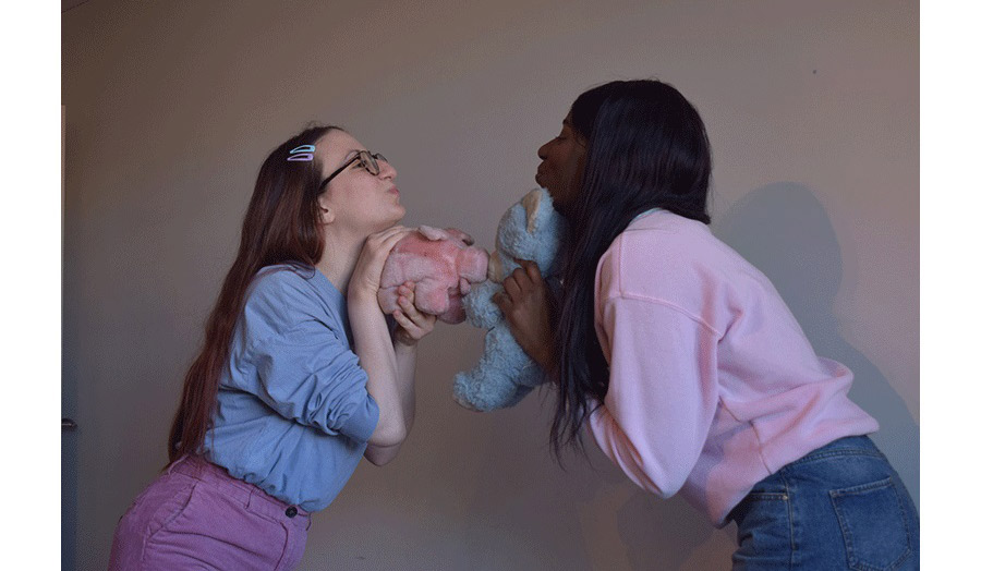 Two smiley woman facing to each other holding baby dolls