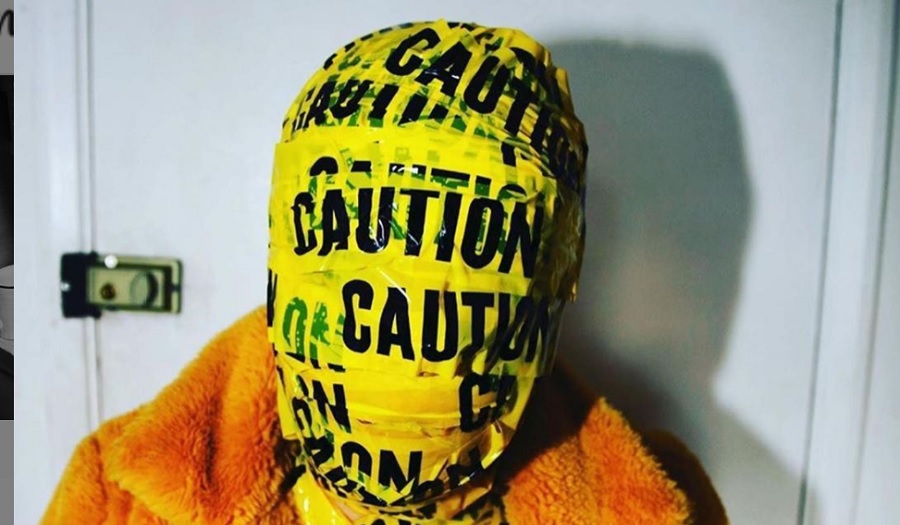 woman's face wrapped in yellow caution tape