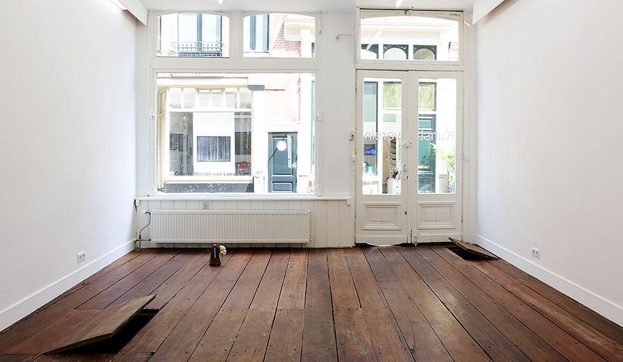 View from inside of an empty white room with a wooden floor over looking to the high street