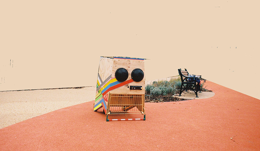 Assemblage piece reconstructing a sound system displayed next to a street bench