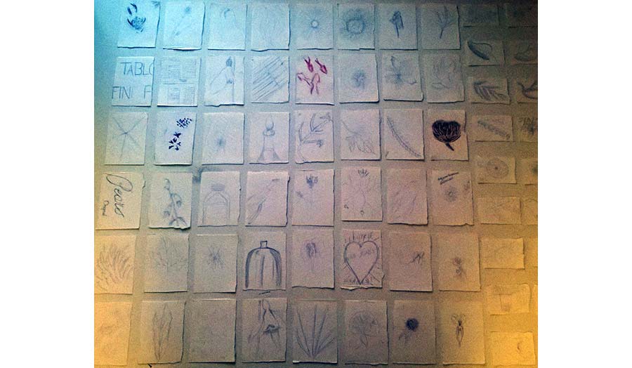 Little drawings stuck on a wall making a grid