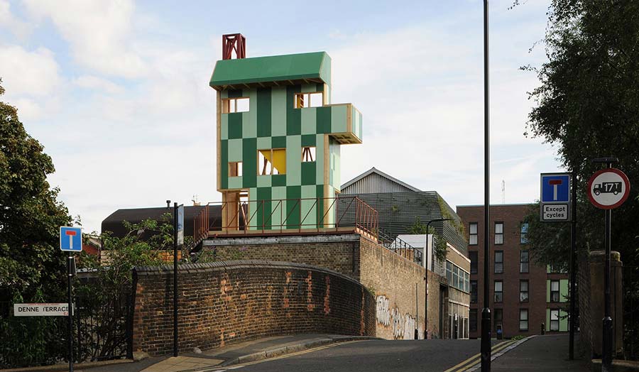 Potemkin Theatre, a green wooden building rising over the lower level brick buildings beside it.