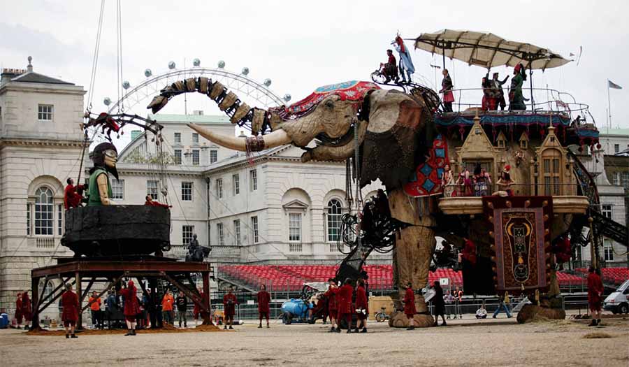 Actors performing on a big elephant structure in london
