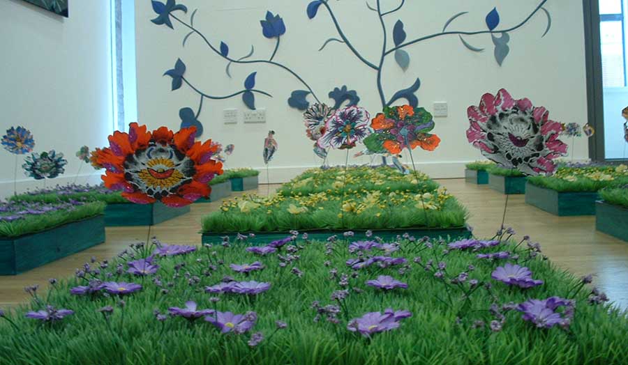 large, colourful paper flowers on Astroturf plinths