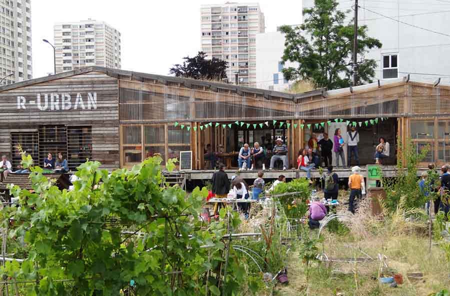 people gathered for an event in a timber structure beyond an allotment 