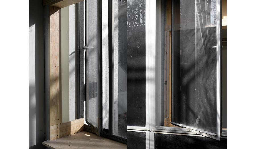 Sunlight streaming through partially open windows, casting shadows on a wooden sill