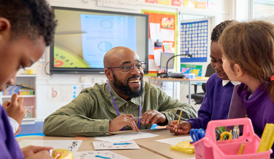 Male London Met teacher talking to a student in a placement school