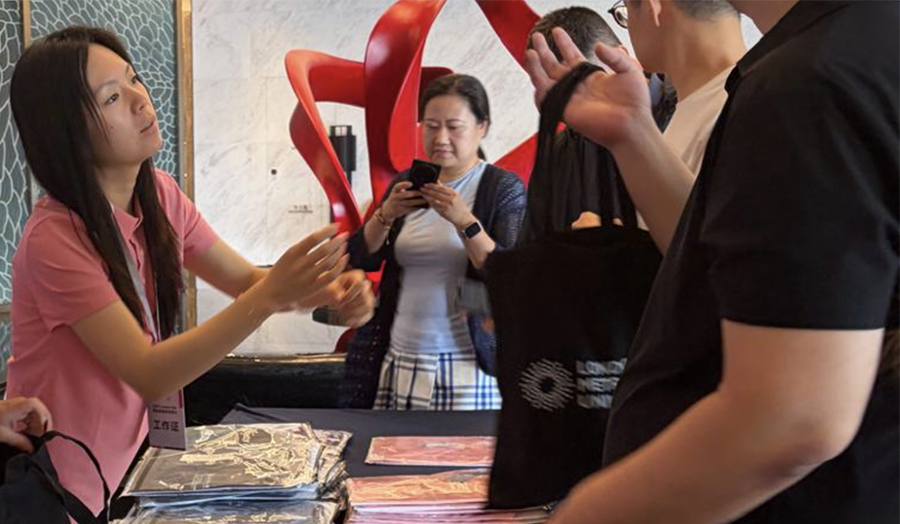 Staff member hands out a London Met tote bag 