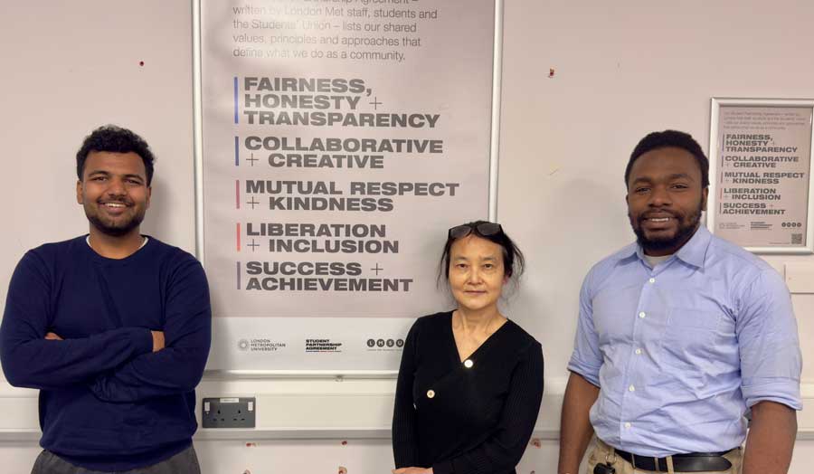 three students curriculum partners standing infront of the student partnership agreement.