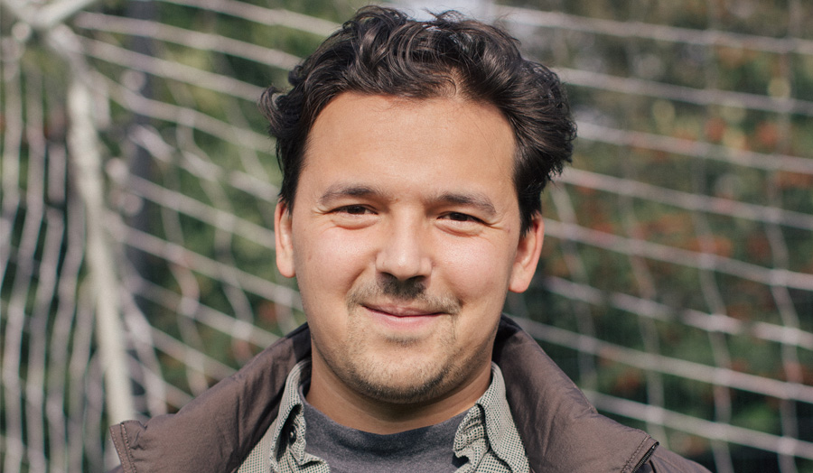 London Met alumnus Joshua Derraji standing in front of football goal posts