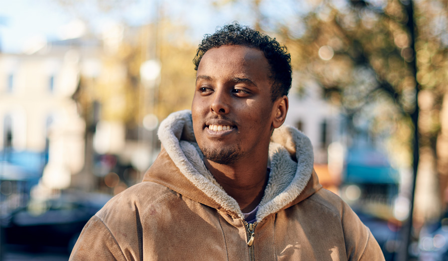 London Met graduate Diini wearing a brown hoodie