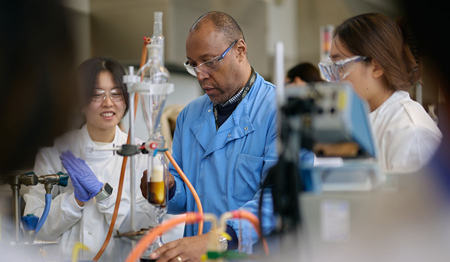 Don in the superlab with students next to him smiling