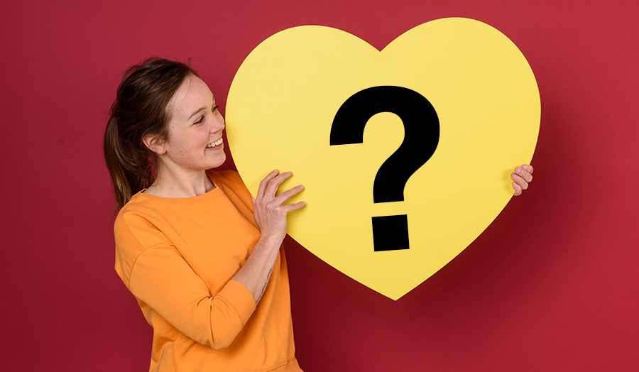Student holding a heart with a question mark in it