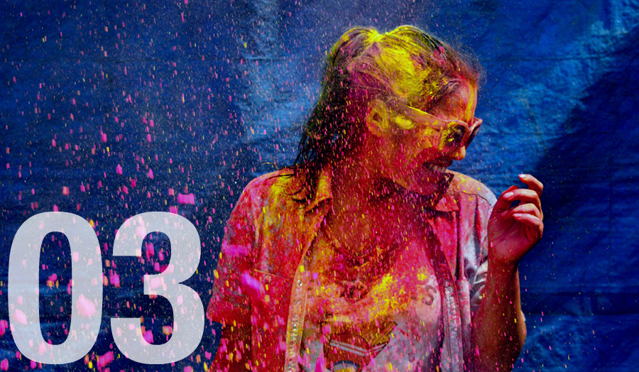 Student smiling covered in paint for holi festival