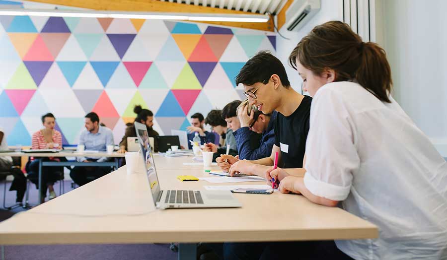 Colleagues collaborating in a modern colourful open working space