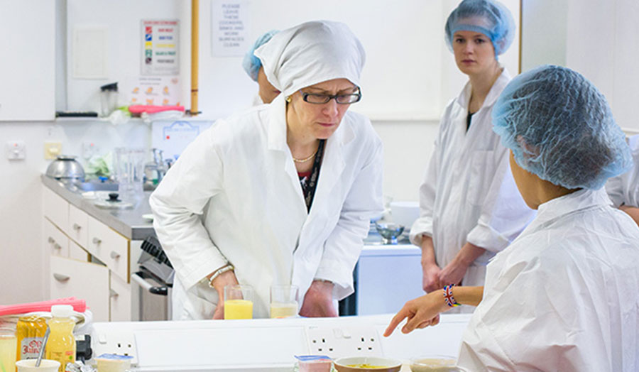 Dietetics lecturer at London Met inspecting student work in nutrition lab