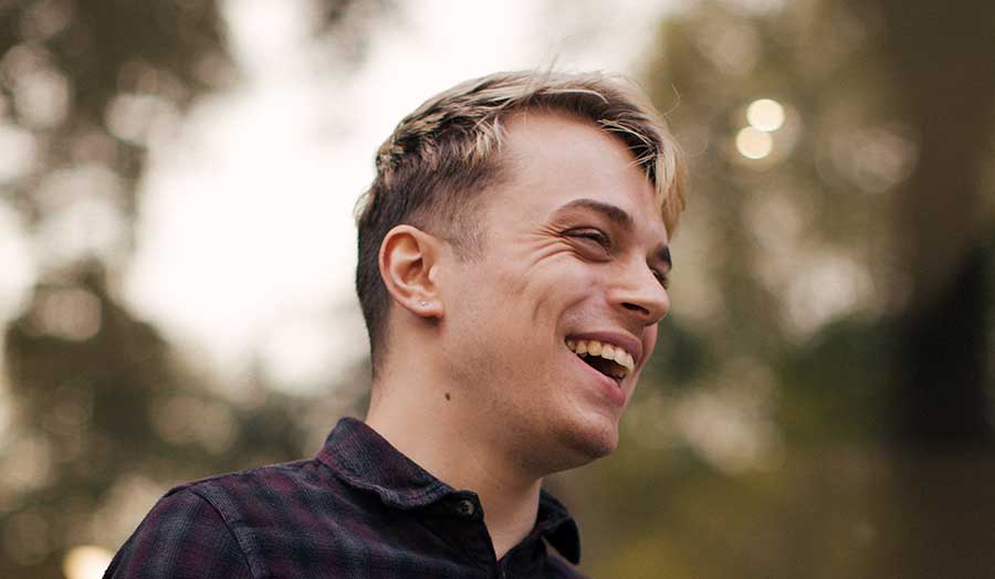 Nils laughing in front of some trees