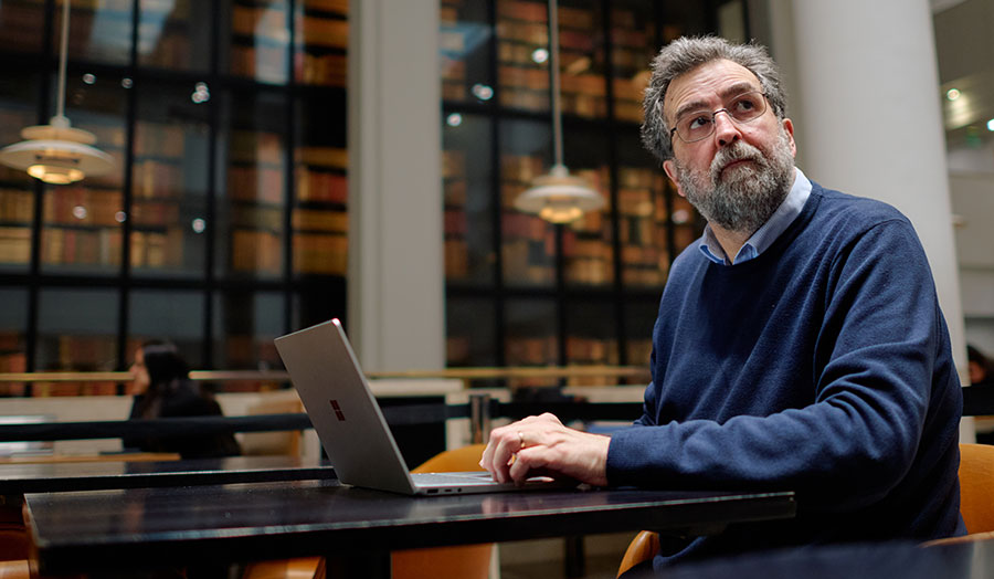 Andrew at a laptop looking wistful in the British Library
