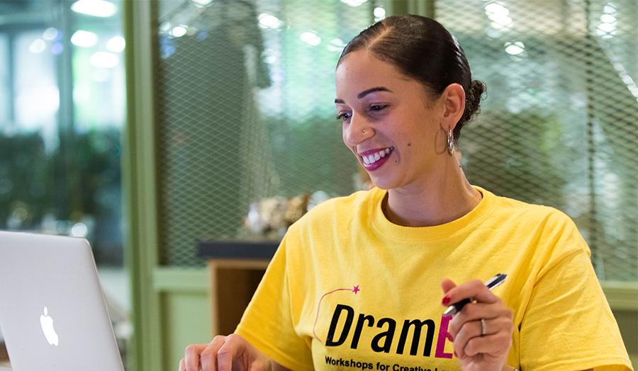 Image of Grace Francis at a desk wearing a DramEd tshirt