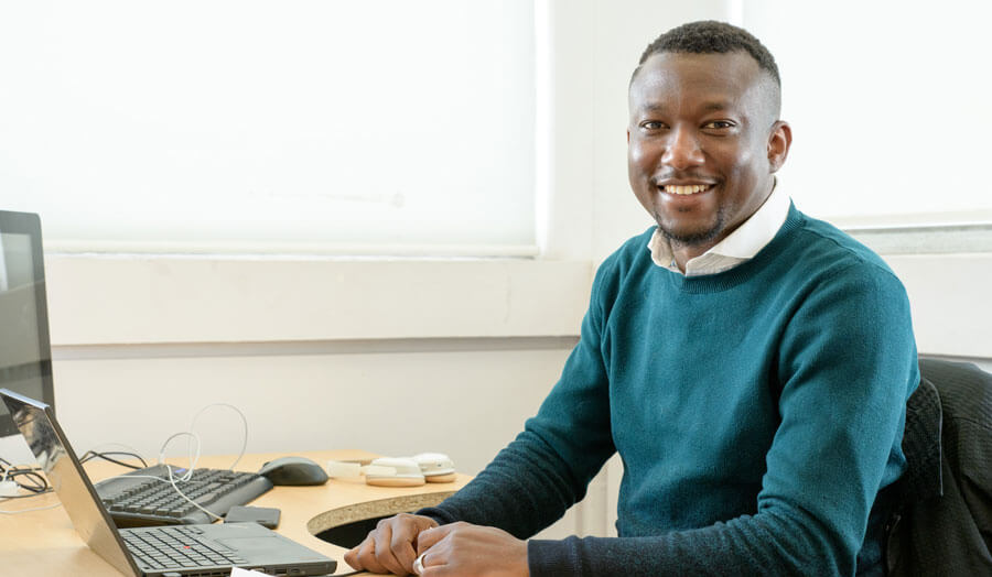 Male student Ola Lawal at his desk in a computer lab.