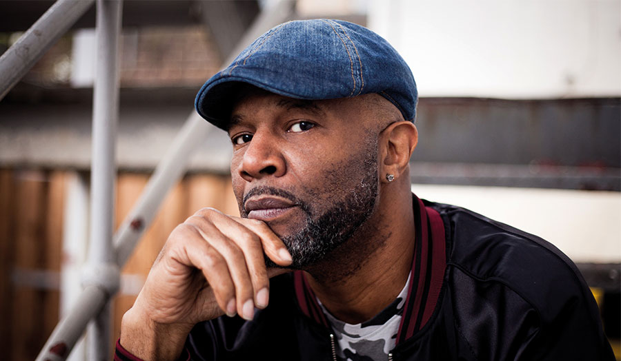 Raymond Stevenson wearing a cap and looking thoughtful