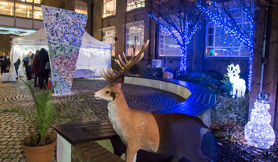 Colourful photo of Courtyard with Cass artwork in the background and reindeer in foreground