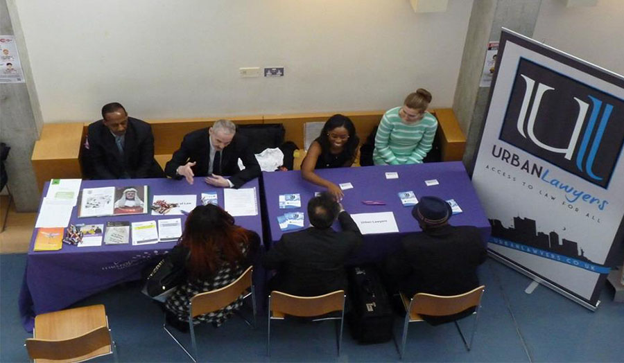 Students greeting employers at the law fair