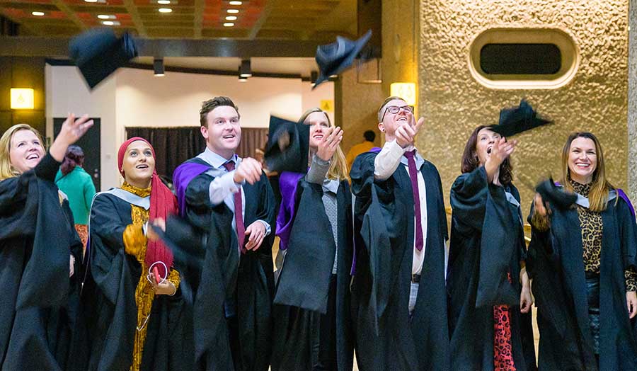 Happy graduates throwing their hats in the air, as is tradition