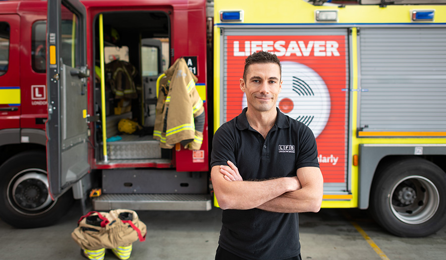 Greg Lessons standing in front of a fire engine.