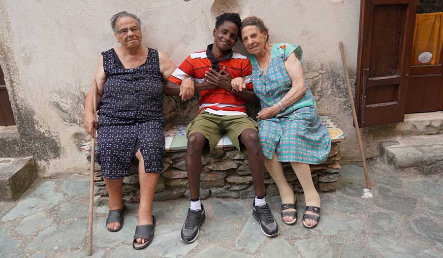 One of the refugees sat with two older locals