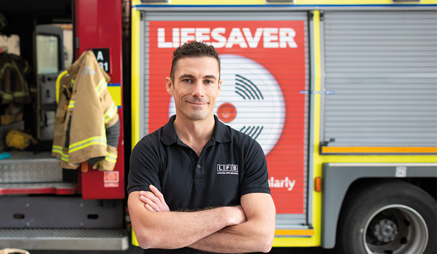 Greg Lessons standing in front of a fire engine