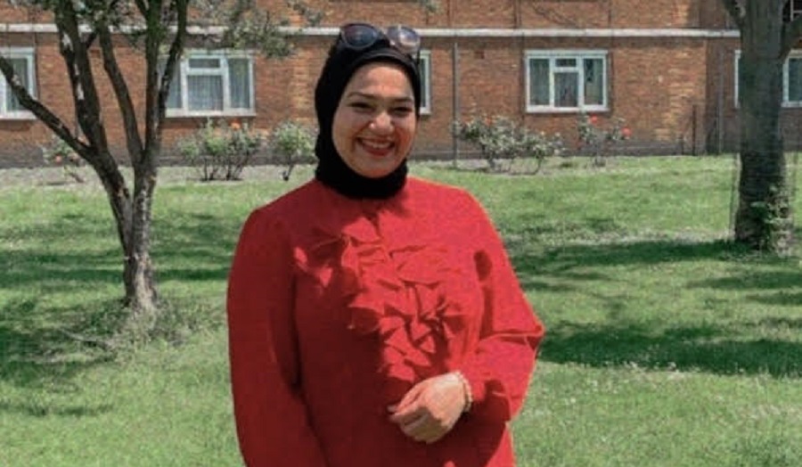 woman wearing red jumper and black headscarf smiling