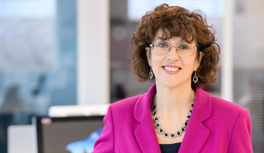 woman wearing pink jacket smiling at the camera