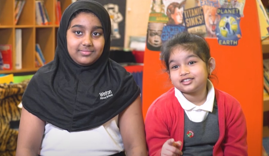 two young children in school uniform, both girls