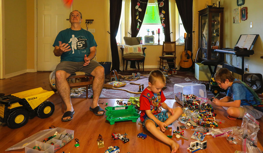 dad and children in a room strewn with toys