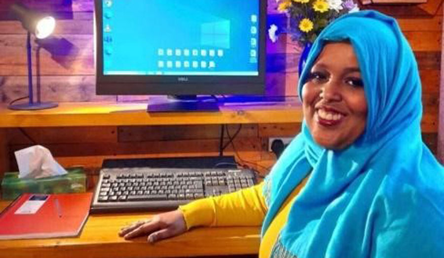 woman wearing blue hijab sitting at a computer