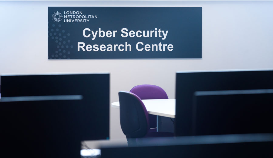 Desks in front of a sign reading Cyber Security Research Centre