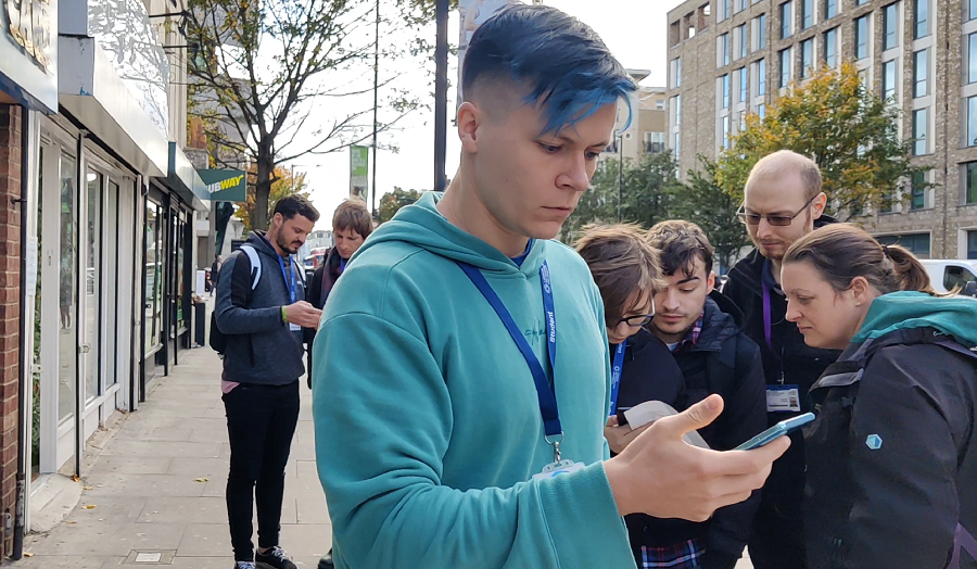 students looking at phones, engaged in an augmented reality game