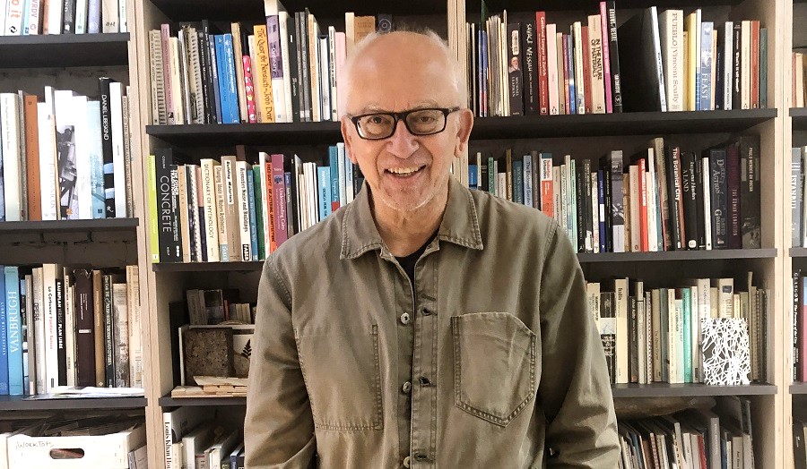Man wearing glasses standing in front of book shelves