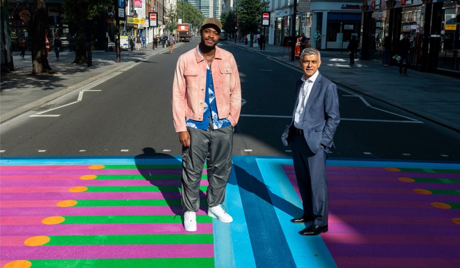 Two men crossing a road at a brightly coloured pedestrian crossing