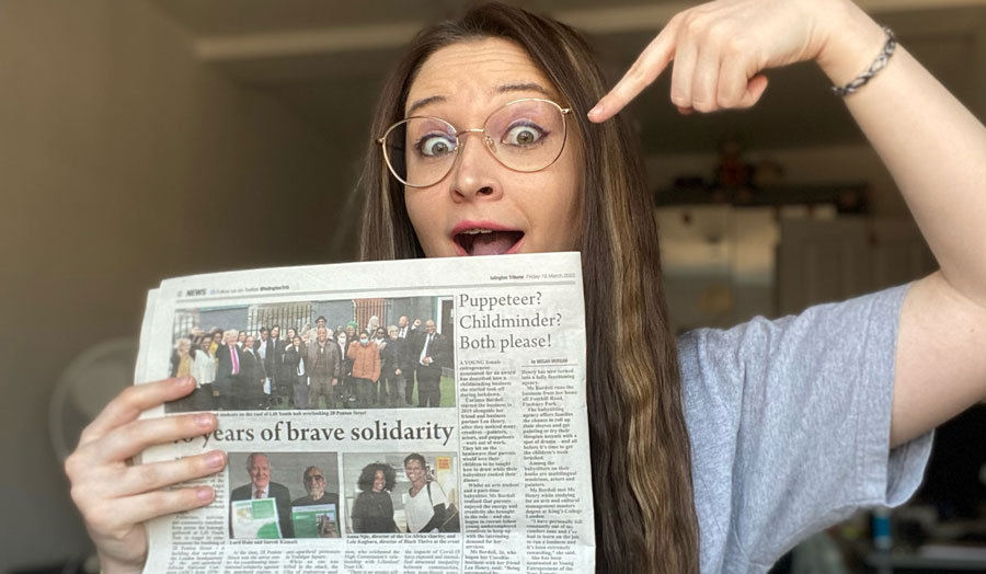 Female student journalist holding a newspaper in which her article is printed