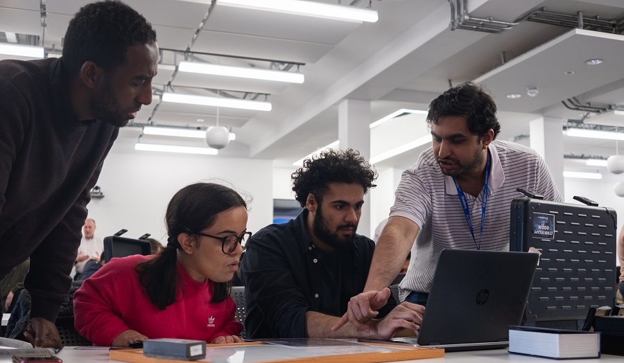 Four people working around a computer