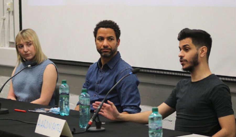 two men and a woman sitting at a panel