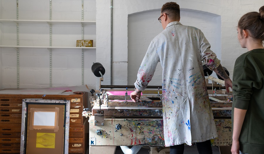 a man in a white coat screen printing