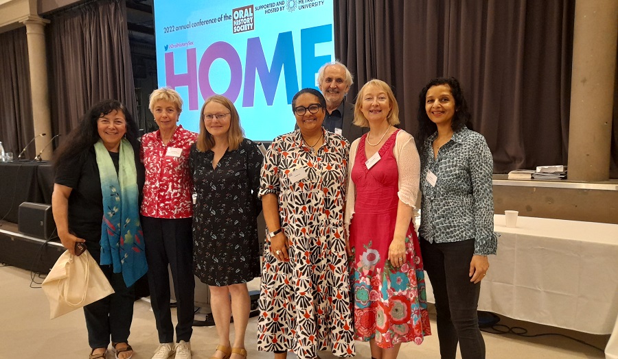 the conference organising team - a group of people in front of a screen reading 'Home'