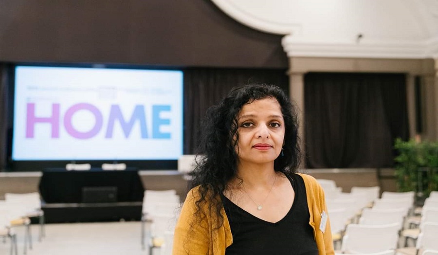 Dr Alya Khan in foreground, 'home' on screen in background