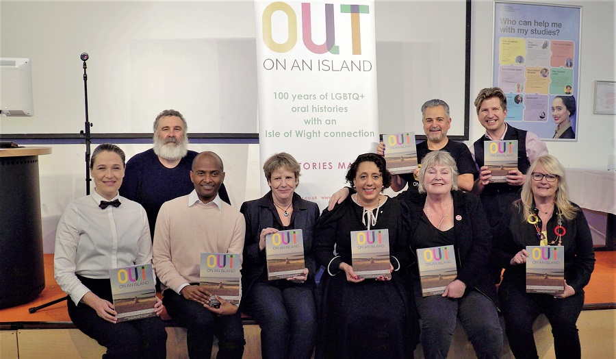 group of men and women each holding a book called 'Out on an Island'
