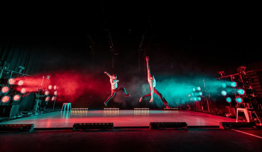 Scene from Rishi Trikha's show 'Stuntman' depicting two actors on a stage leaping athletically